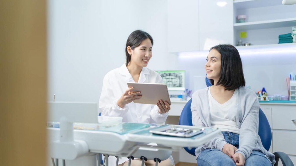When should I see a dentist for a Hollywood smile? dentist consulting a patient in a modern dental clinic