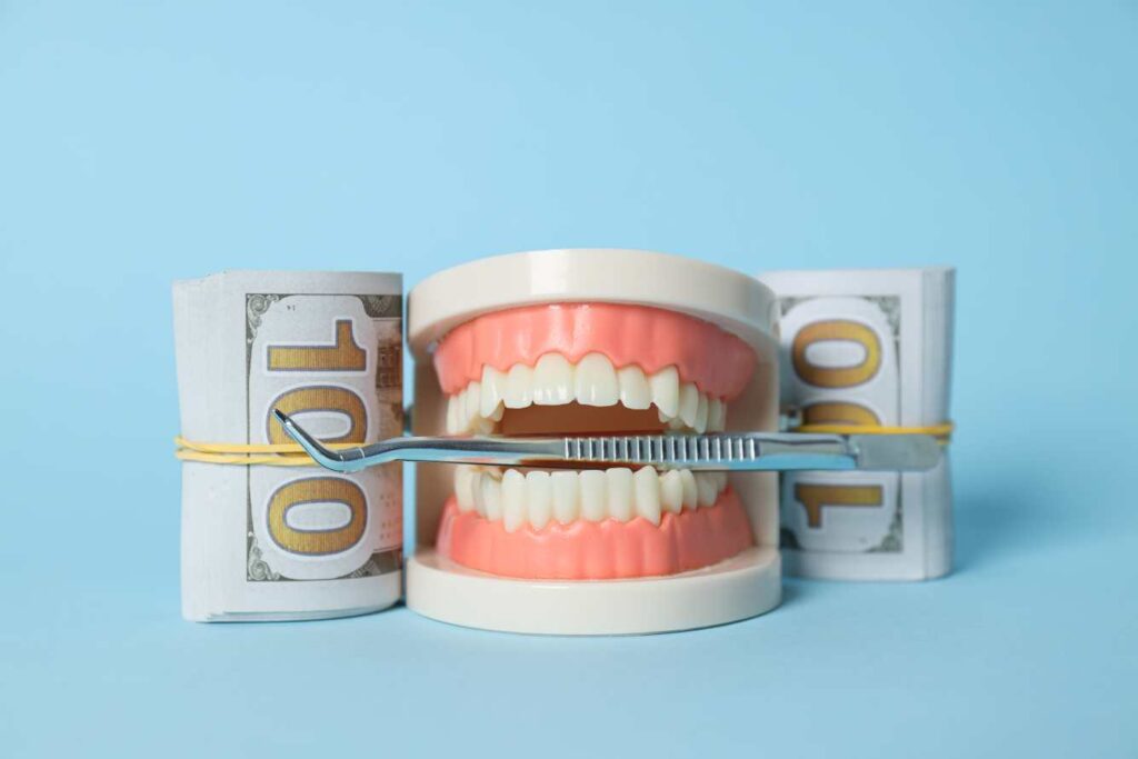 Dental model with money and probe showing Hollywood smile cost in Spain