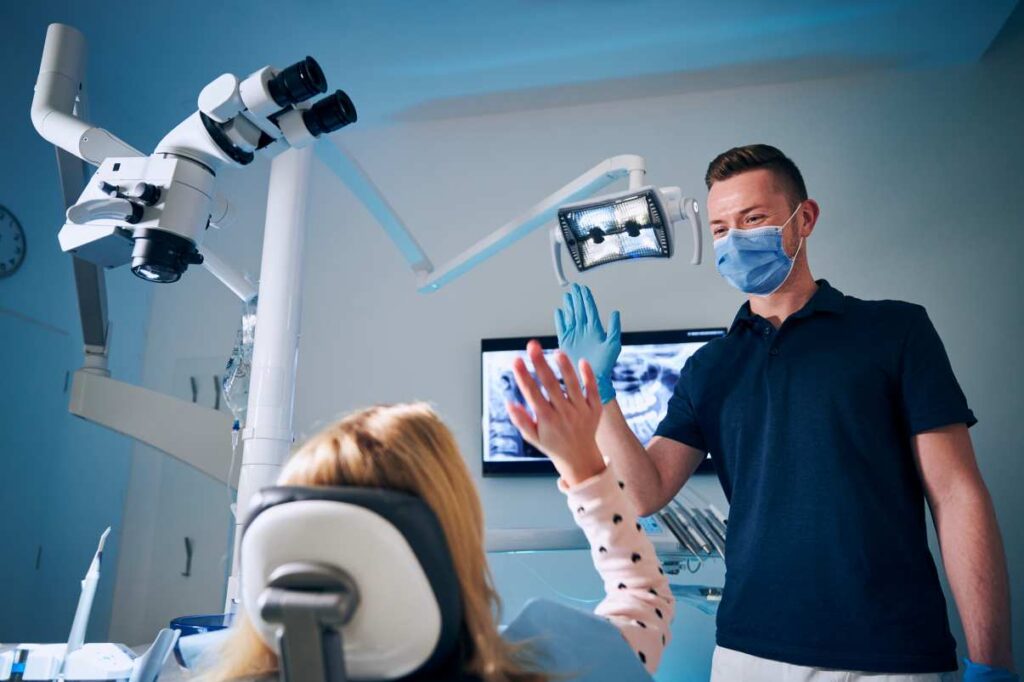 Patient high-fiving dentist during Hollywood smile check-up in a Spanish dental clinic