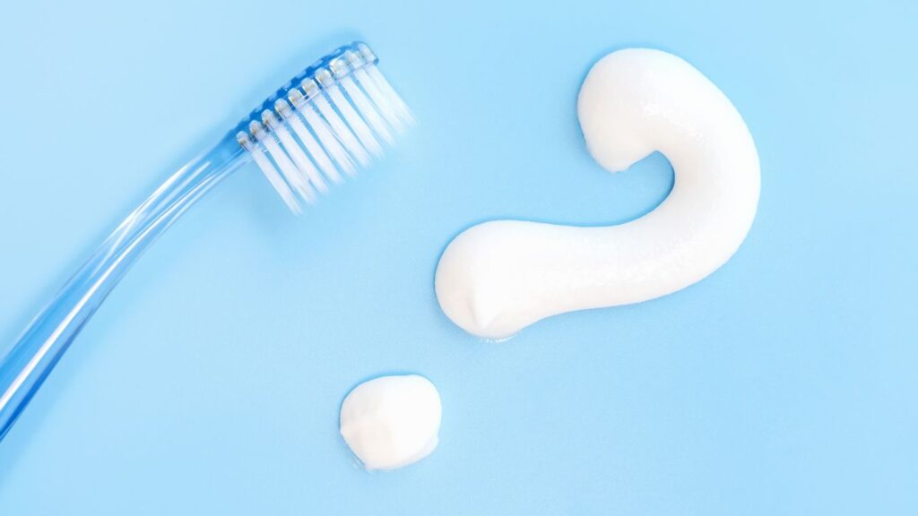 Toothbrush and toothpaste forming a question mark (questions to ask a clinic)