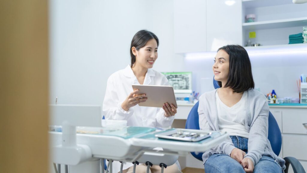 Dentist consulting with a patient about treatment options for bonding, veneers, and crowns