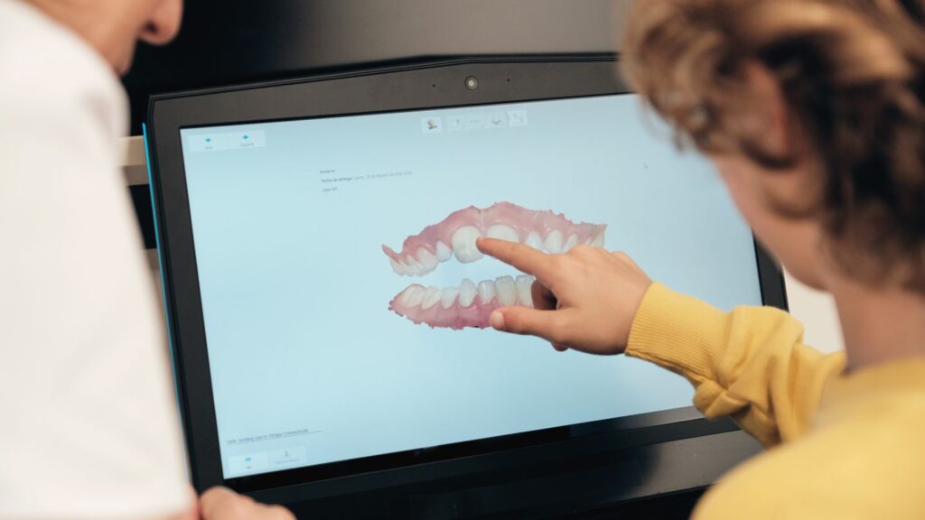 Patient pointing at a digital smile design on a computer screen during a Hollywood smile consultation.