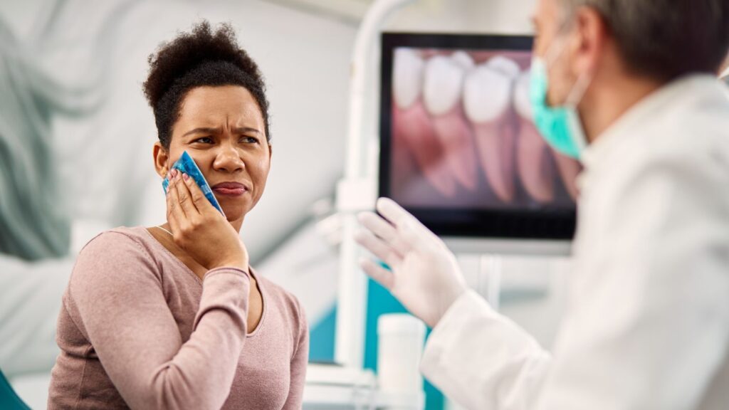 Dental consultation showing a patient in discomfort while the dentist discusses treatment risks.