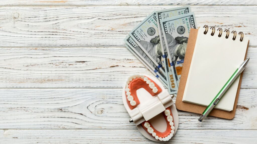 Dental model with US dollar bills and notebook illustrating zirconia crown cost in Turkey