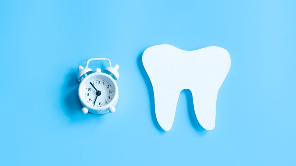 Tooth model and alarm clock symbolizing the treatment time for zirconia crowns in Turkey