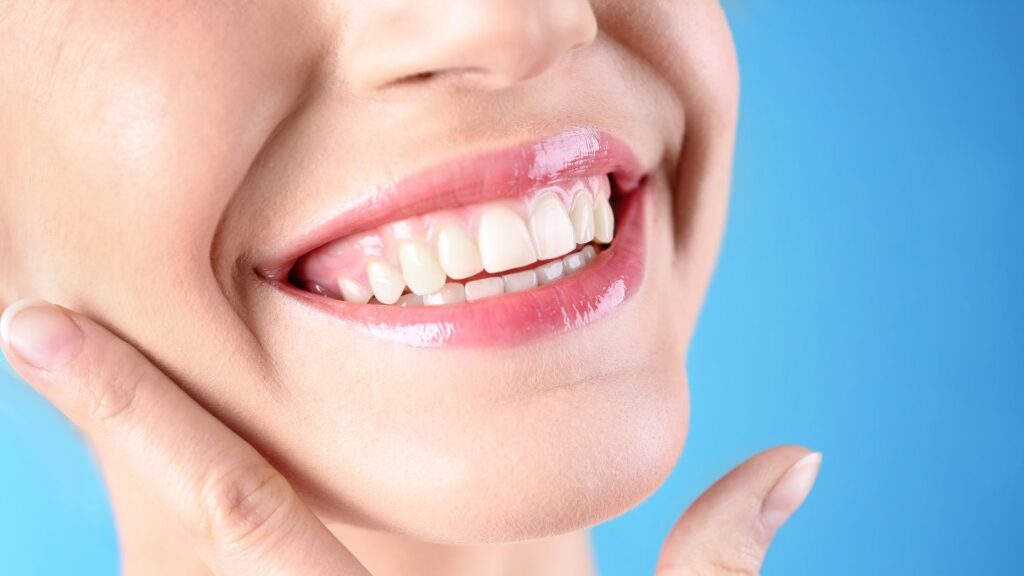 Close-up of a person smiling with bright, healthy-looking teeth, representing a healthy Hollywood smile makeover.